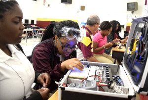 Tyner students (from left) Jada Beckett and Takayla Sanford work on buidling circuits on the digital analog trainer, while teacher Bryan Robinson instructs Brookeana Willams and Noemy Marberry about soldering. Tyner High teacher Bryan Robinson has started a mechatronics program that offers student the opportunity to graduate with a specific certification that will aid them in finding jobs with high-tech companies. Photo by Robin Rudd /Times Free Press.